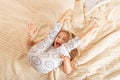 Beautiful little girl in pajamas jumping on the bed at home. Stay at home during coronavirus covid-19 lockdown and have a fun. Royalty Free Stock Photo