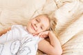 Beautiful little girl in pajamas lying on the bed at home. Stay at home during coronavirus covid-19 lockdown and have a fun. Happy Royalty Free Stock Photo