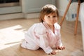 Beautiful little girl in pajamas on wooden floor