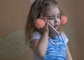 Beautiful little girl and pigtails holding a phone is calling to somebody. background Gray Royalty Free Stock Photo