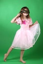 Beautiful little girl in pink butterfly dress and carnival mask dancing Royalty Free Stock Photo