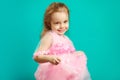 Beautiful little girl in pink dress on blue background. Royalty Free Stock Photo