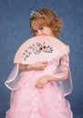 Beautiful little girl in pink dress with a fan Royalty Free Stock Photo