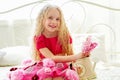 Beautiful little girl in pink dress sitting on the bed Royalty Free Stock Photo