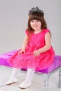 Beautiful little girl in pink Princess dress with crown sitting Royalty Free Stock Photo