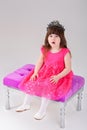 Beautiful little girl in pink Princess dress with crown sitting Royalty Free Stock Photo