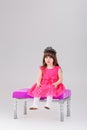 Beautiful little girl in pink Princess dress with crown sitting Royalty Free Stock Photo