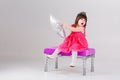 Beautiful little girl in pink Princess dress with crown sitting Royalty Free Stock Photo