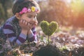 Beautiful little girl planting a heart-shaped tree and dreaming of a beautiful future Royalty Free Stock Photo