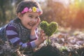Beautiful little girl planting a heart-shaped tree and dreaming of a beautiful future Royalty Free Stock Photo