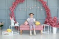 Beautiful little girl playing with colorful Easter eggs and Easter bunny. Easter interior room. Family holidays, traditions. Harve