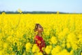 Cute little girl playing with yellow flowers in summer field. Happy child outdoors Royalty Free Stock Photo