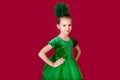 Beautiful little girl princess dancing in luxury green dress isolated on red background. Carnival party with costumes Royalty Free Stock Photo