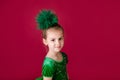 Beautiful little girl princess dancing in luxury green dress isolated on red background. Carnival party with costumes Royalty Free Stock Photo