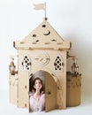 Beautiful little girl in princess dress playing with her toy castle. Royalty Free Stock Photo