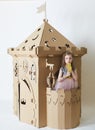 Beautiful little girl in princess dress playing with her toy castle. Royalty Free Stock Photo