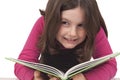 Beautiful little girl reading a book and smiling Royalty Free Stock Photo