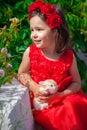 A beautiful little girl in a red dress holding a rabbit Royalty Free Stock Photo