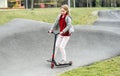 Beautiful little girl rides a scooter in a extreme park Royalty Free Stock Photo