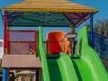 A beautiful little girl is riding a water slide in the water park Royalty Free Stock Photo