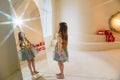 Beautiful little girl in a shiny dress looking in the mirror at her reflection. Royalty Free Stock Photo