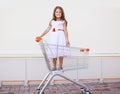 Beautiful little girl in shopping cart having fun outdoors Royalty Free Stock Photo