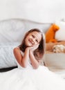 Beautiful little girl sits on the floor in a light room. Happy Smiling Child Royalty Free Stock Photo