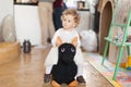 Beautiful little girl sitting on a donkey toy