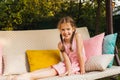 Beautiful little girl sitting on a porch swing Royalty Free Stock Photo