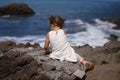 Beautiful little girl sitting on a rock and looking into the dis Royalty Free Stock Photo