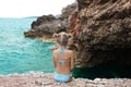 Beautiful little girl is sitting on the rocky beach Royalty Free Stock Photo