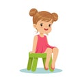Beautiful little girl sitting on a small green stool, colorful character