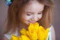 Beautiful little girl smelling the aroma of bouquet of fresh tulips. Spring and summer portrait of cute child holding Royalty Free Stock Photo