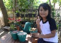 Beautiful Little Girl Smile With Thumbs Up When Sit Holding Plant In Pots Look To Camera