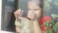 Beautiful little girl smiling and watching out the window. A child looks out the window. Portrait of cheerful kid. self Royalty Free Stock Photo