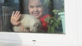 Beautiful little girl smiling and watching out the window. A child looks out the window. Portrait of cheerful kid. self Royalty Free Stock Photo