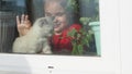 Beautiful little girl smiling and watching out the window. A child looks out the window. Portrait of cheerful kid. self Royalty Free Stock Photo