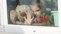 Beautiful little girl smiling and watching out the window. A child looks out the window. Portrait of cheerful kid. self Royalty Free Stock Photo