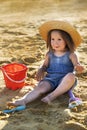 Beautiful little girl in a straw hat on a sandy beach Royalty Free Stock Photo