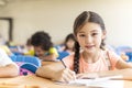 Beautiful little girl studying in the classroom