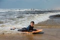 pretty little girl enjoying surfing the waves with a bodyboard during her vacation Royalty Free Stock Photo