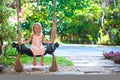 Beautiful little girl swinging on swing in a cozy Royalty Free Stock Photo