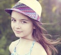 Beautiful little girl teenager in a hat, summer outdoors, emotions of happiness smiles and rest. Long hair develops in Royalty Free Stock Photo