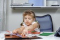 Beautiful little girl in a white blouse cuts out of paper. children`s creativity