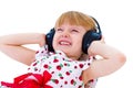 beautiful little girl in white dress listening to music with headphones Royalty Free Stock Photo