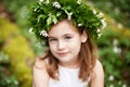 Beautiful  little girl in a white dress  in the spring wood. Portrait of the pretty little girl with a wreath from spring flowers Royalty Free Stock Photo
