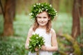 Beautiful  little girl in a white dress  in the spring wood. Portrait of the pretty little girl with a wreath from spring flowers Royalty Free Stock Photo