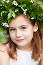 Beautiful  little girl in a white dress  in the spring wood. Portrait of the pretty little girl with a wreath from spring flowers Royalty Free Stock Photo