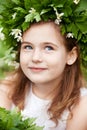 Beautiful  little girl in a white dress  in the spring wood. Portrait of the pretty little girl with a wreath from spring flowers Royalty Free Stock Photo