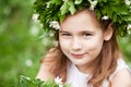 Beautiful  little girl in a white dress  in the spring wood. Portrait of the pretty little girl with a wreath from spring flowers Royalty Free Stock Photo